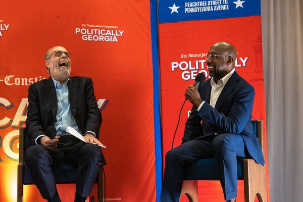 Bill Nigut (left) enjoys a lighthearted moment with U.S. Sen. Raphael Warnock at a Politically Georgia event in Savannah.