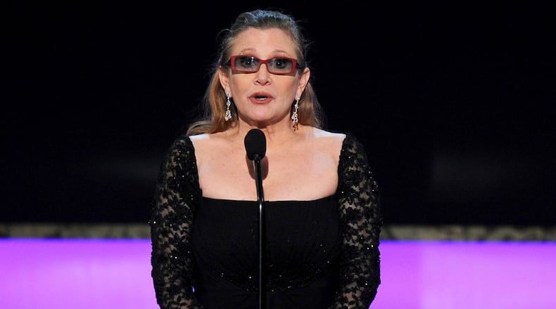 FILE - In this Sunday, Jan. 25, 2015 file photo, Carrie Fisher presents the life achievement award on stage at the 21st annual Screen Actors Guild Awards at the Shrine Auditorium in Los Angeles. Fisher has reportedly been transported to a hospital after suffering a severe medical emergency on a flight Friday, Dec. 23, 2016. (Photo by Vince Bucci/Invision/AP, File)