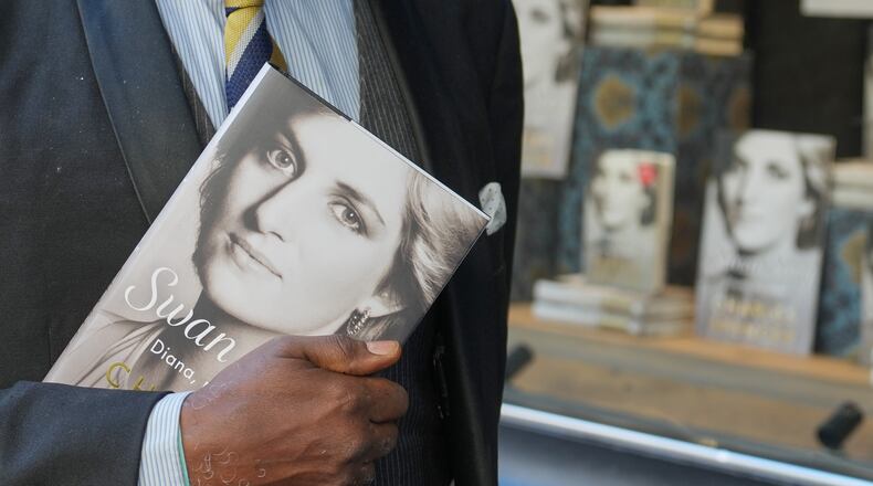 A man holds a copy of the new book by Earl Spencer, brother of the late Princess Diana, entitled "Swan Song: Diana, My Sister," outside a bookshop in central London, Tuesday, Sept. 22, 2026. (AP Photo/Kin Cheung)