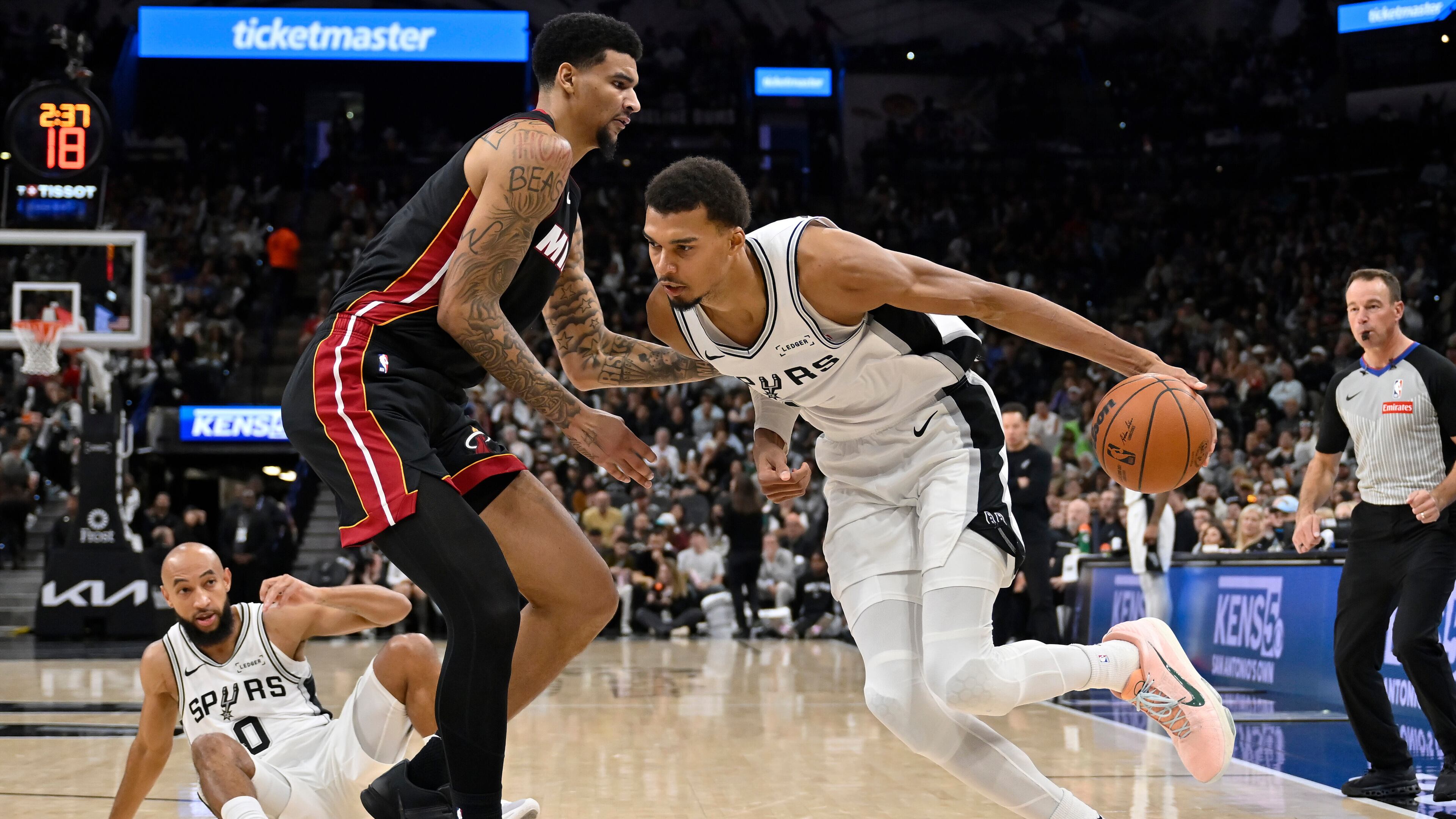 San Antonio Spurs center Victor Wembanyama, right, drives against Miami Heat center Kel'el Ware, front left, during the second half of an NBA basketball game, Thursday, Oct. 30, 2025, in San Antonio. (AP Photo/Darren Abate)