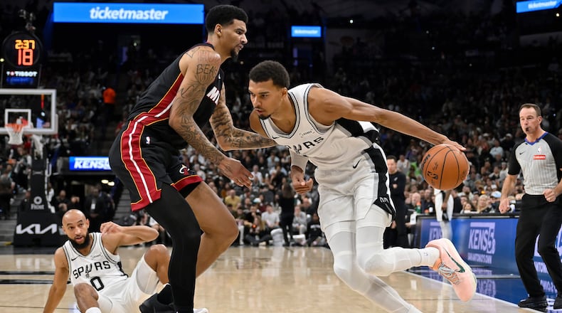 San Antonio Spurs center Victor Wembanyama, right, drives against Miami Heat center Kel'el Ware, front left, during the second half of an NBA basketball game, Thursday, Oct. 30, 2025, in San Antonio. (AP Photo/Darren Abate)