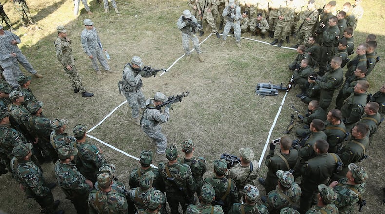 YAVOROV, UKRAINE - SEPTEMBER 16: Members of the U.S. Army 173rd Airborne Brigade demonstrate urban warfare techniques as Bulgarian (bottom) and Ukrainian soldiers look on on the second day of the "Rapid Trident" NATO military exercises on September 16, 2014 near Yavorov, Ukraine. The two-week exercises include participating units from a variety of NATO and NATO-associate countries as well as Ukrainian troops. Meanwhile the Ukrainian parliement today ratified an associate agreement with the European Union and also agreed on a autonomous status for the separatist-controlled portion of eatern Ukraine. (Photo by Sean Gallup/Getty Images)