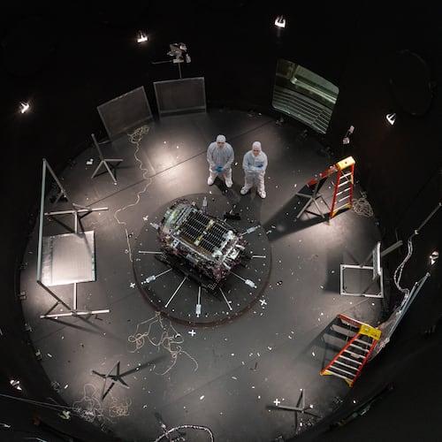 This photo provided by NASA shows Kieran Wilson, LINK’s principal investigator, and Hunter Robertson, a space systems engineer, both at Katalyst Space, standing next to their spacecraft inside the SES (Space Environment Simulator) at NASA’s Goddard Space Flight Center in Greenbelt, Md., April 17, 2026, ahead of thermal vacuum testing. (Sophia Roberts/NASA via AP)
