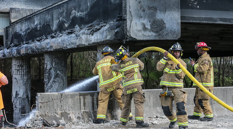 March 31, 2017 Atlanta: Atlanta firefighters remained on the scene putting out a smoldering fire Friday, March 31, 2017 at the I-85 collapse site while construction crews made their way into the zone to begin work. Three people were arrested late Friday in connection with setting the fire. JOHN SPINK /JSPINK@AJC.COM