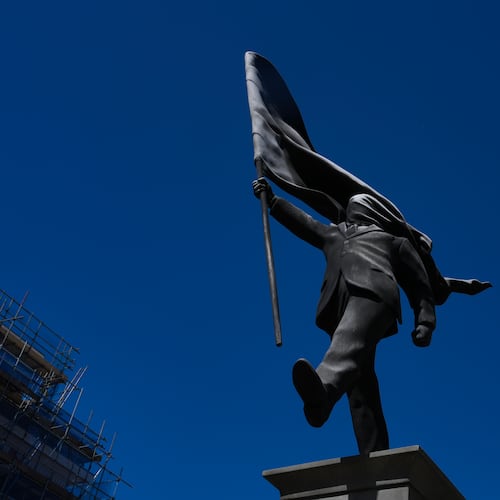 A statue of a man holding a flag covering his face, and signed 'Banksy', which has appeared in Waterloo Place in London, Thursday, April 30, 2026. (AP Photo/Kin Cheung)