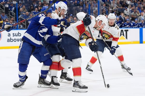 Florida Panthers defenseman Nate Schmidt (88) keeps the puck from Tampa Bay Lightning center Yanni Gourde (37) during the second period in Game 2 of an NHL hockey Stanley Cup first-round playoff series, Thursday, April 24, 2025, in Tampa, Fla. (AP Photo/Chris O'Meara)