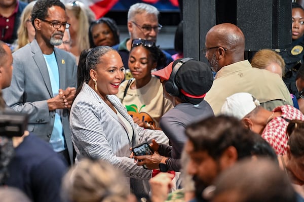 Former Atlanta mayor Keisha Lance Bottoms is running in tandem with U.S. Sen. Jon Ossoff. Here, she engages in conversation with an attendee at their joint rally last month in Savannah. (Sarah Peacock for the AJC)