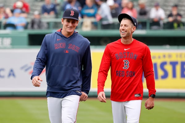 Boston Red Sox outfielder Roman Anthony, left, smiles as he walks with third base coach Kyle Hudson before making his first major league start in a baseball game against the Tampa Bay Rays at Fenway Park, Monday, June 9, 2025, in Boston. (AP Photo/Mary Schwalm)