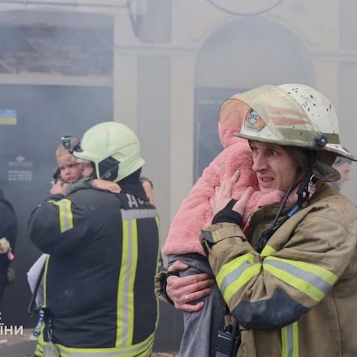In this photo provided by the Ukrainian Emergency Service, rescuers evacuate children after Russian drones hit a city kindergarten during an attack in Kharkiv, Ukraine, Wednesday, Oct. 22, 2025. (Ukrainian Emergency Service via AP)