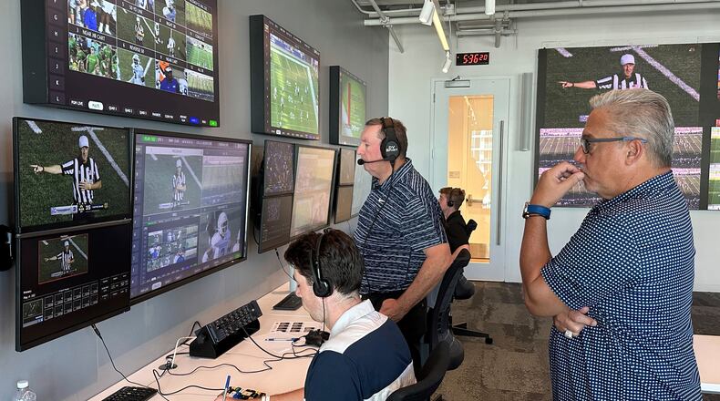 FILE - Alberto Riveron, right, the Atlantic Coast Conference supervisor of football officials, works in the league's new gameday operations center, Saturday, Sept. 2, 2023, in Charlotte, N.C. (AP Photo/Aaron Beard, File)