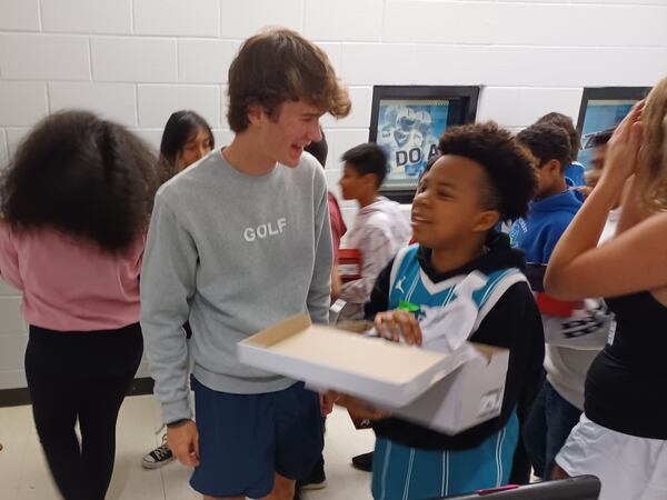 Collin Maher, left, receives thanks from students who received shoes as a result of his efforts. (Photo Courtesy of Bob Pepalis)