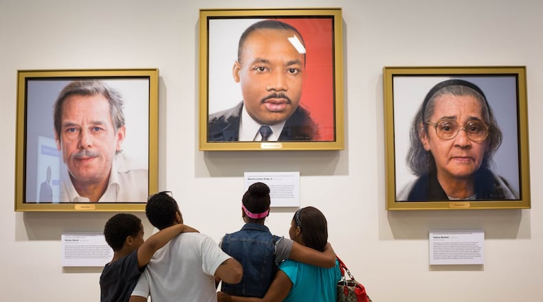 Visitors to the National Center for Civil and Human Rights look at a portrait of Martin Luther King Jr. A new exhibit of artifacts from the Morehouse collection of King’s papers will go on display this weekend at the center, in time for the King Holiday. CONTRIBUTED: NATIONAL CENTER FOR CIVIL AND HUMAN RIGHTS