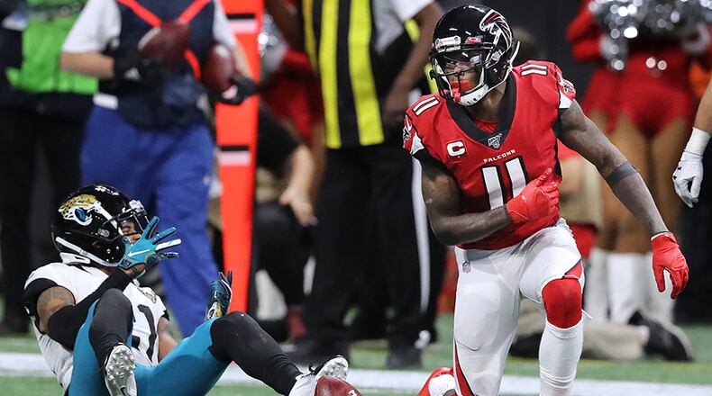 Falcons wide receiver Julio Jones spins the ball on the turf after catching a pass past Jacksonville Jaguars cornerback A.J. Bouye during the second half Sunday, Dec. 22, 2019, at Mercedes-Benz Stadium in Atlanta.
