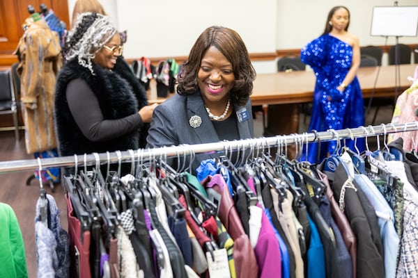 State Sen. Tonya Anderson browses clothes available for sale or loan at a Fashion Week event at the state Capitol in February. (Arvin Temkar/AJC)