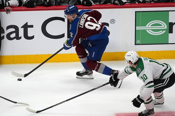Colorado Avalanche left wing Gabriel Landeskog, top, collects the puck as Dallas Stars center Oskar Bäck pursues in the first period of Game 3 of an NHL hockey first-round playoff series Wednesday, April 23, 2025, in Denver. (AP Photo/David Zalubowski)