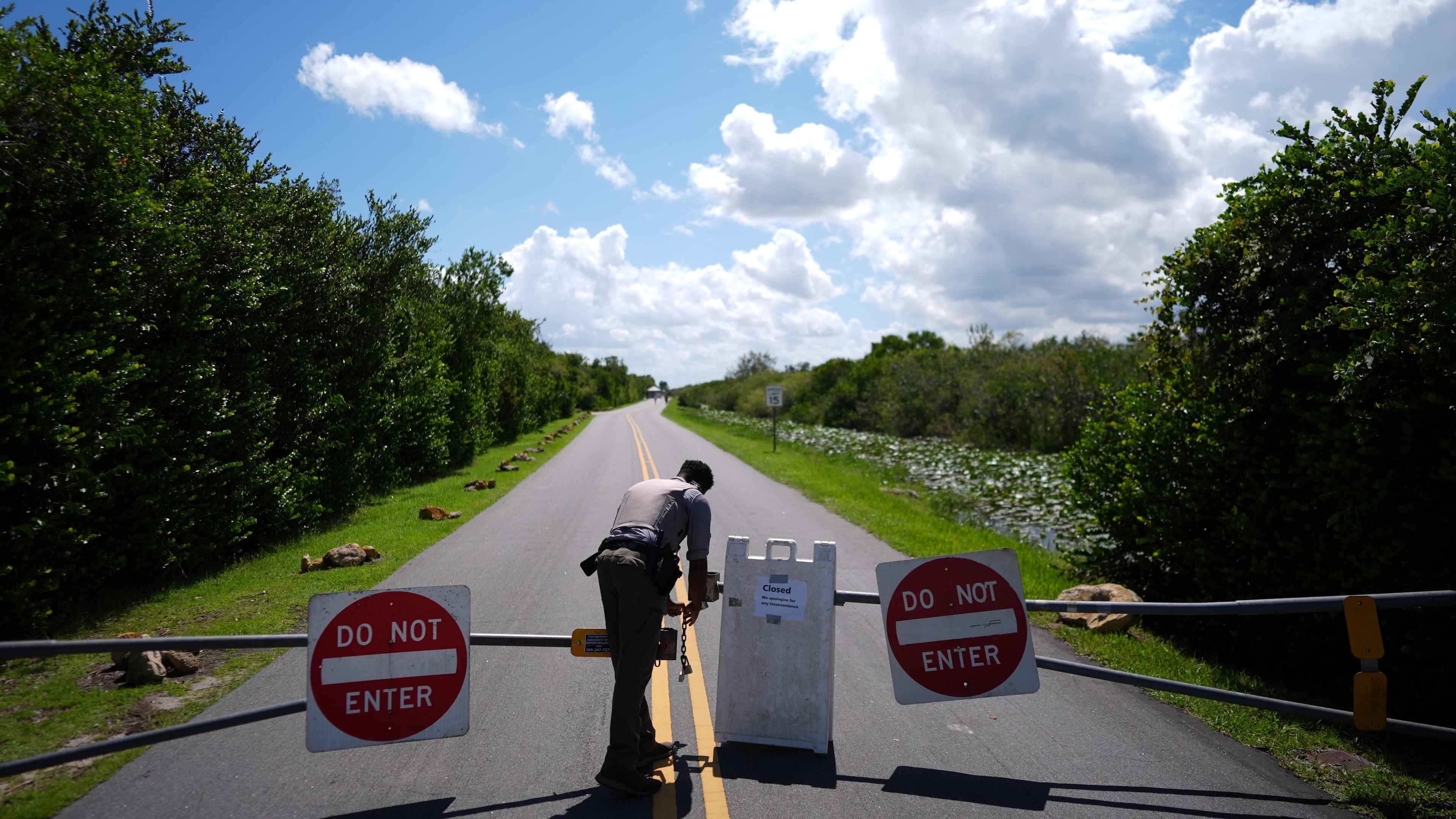 National Park Service law enforcement ranger Greg Freeman opens a locked gate closing vehicle access to the Shark Valley section of Florida's Everglades National Park, as he drives into the park, Wednesday, Oct. 1, 2025. (AP Photo/Rebecca Blackwell)