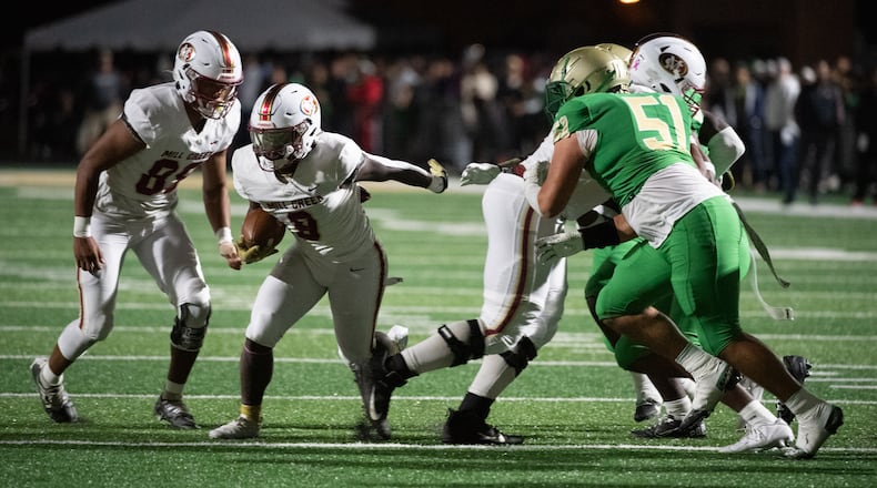 Mill Creek's Cam Robinson looks for yardage during Friday's game against Buford. (Jamie Spaar for the AJC)