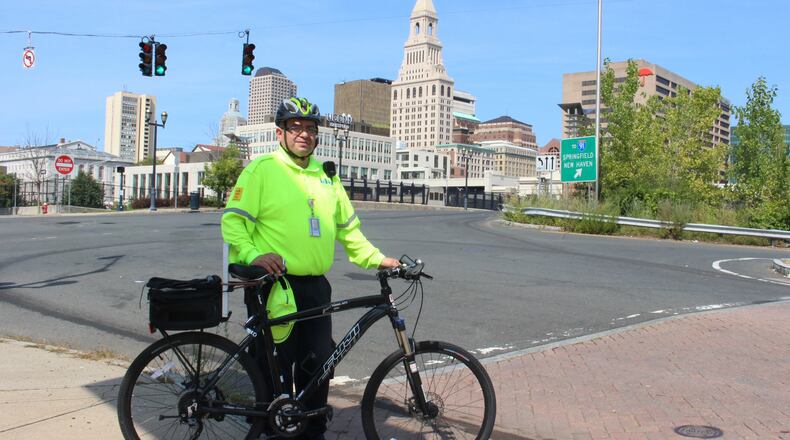 Eddie Zayas, a safety ambassador for the Hartford Business Improvement District, poses during a patrol of downtown streets on Sept. 12, 2017. Zayas is part of a program that provides free roadside assistance to bicyclists who break down in Connecticut's capital city (AP Photo/Pat Eaton-Robb)