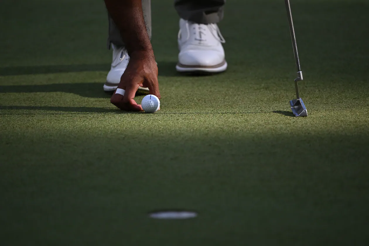 Tiger Woods places his Bridgestone ball on the sixth green at the 2024 Masters. Bridgestone Golf made golf balls under its own brand and others, but will be closing in June. (Hyosub Shin/AJC 2024)