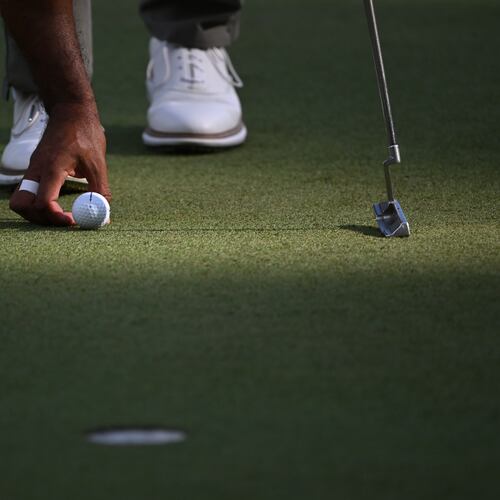 Tiger Woods places his Bridgestone ball on the sixth green at the 2024 Masters. Bridgestone Golf made golf balls under its own brand and others, but will be closing in June. (Hyosub Shin/AJC 2024)