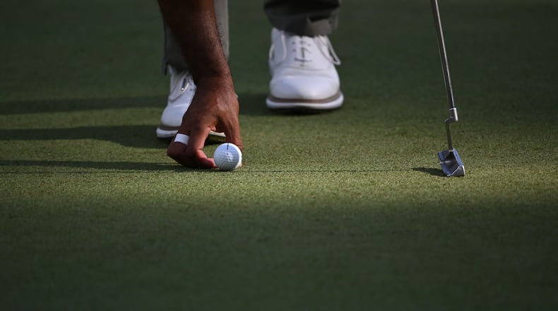 Tiger Woods places his Bridgestone ball on the sixth green at the 2024 Masters. Bridgestone Golf made golf balls under its own brand and others, but will be closing in June. (Hyosub Shin/AJC 2024)