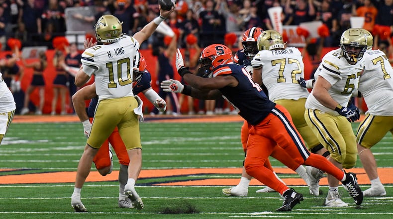 Georgia Tech quarterback Haynes King, left, is pressured Syracuse defensive lineman Fadil Diggs (10) during the second half of an NCAA football game on Saturday, Sept. 7, 2024, in Syracuse, N.Y. Syracuse won 31-28. (AP Photo/Hans Pennink)