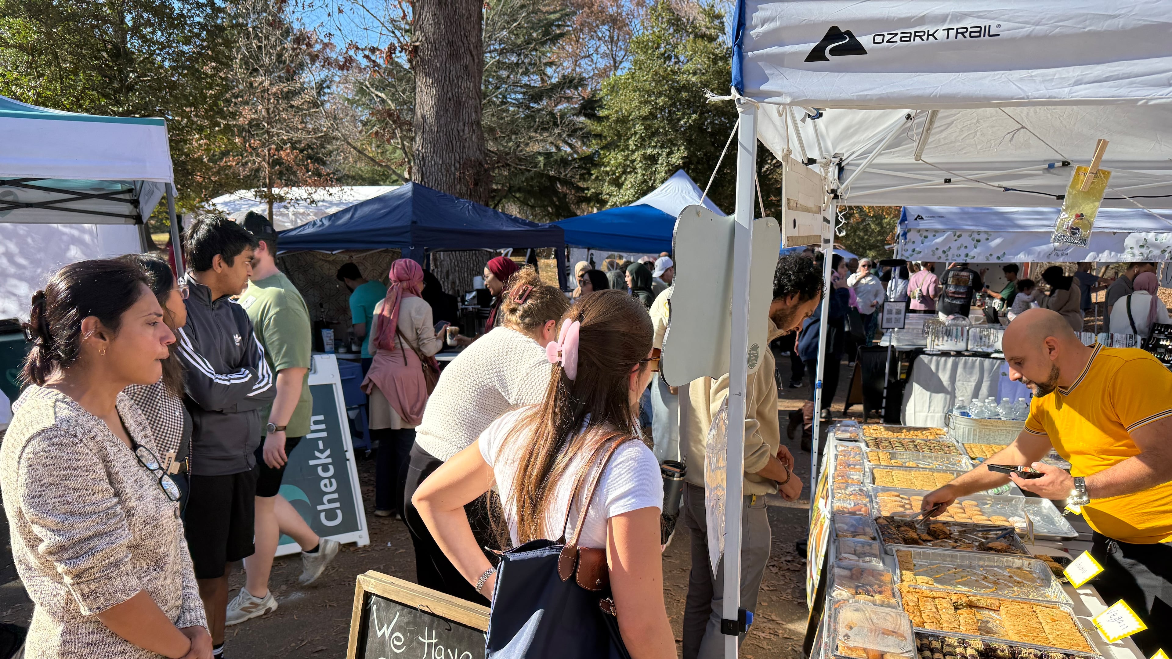 In this photo, Shiraz Taslaq, right, serves pastries from his Lawrenceville-based wholesale pastry business, Baklava, to customers at the the Atlanta Halal Fall Festival. The festival opened at noon Saturday and Sunday under a bright blue sky in Grant Park near downtown Atlanta, in what organizers hope will become a city tradition.
A brisk crowd sampled pastries, meat sandwiches, coffees, and desserts from Muslim traditions across the globe, and shopped for jewelry and crafts. Photos show the festival on Sunday, November 23, 2025 in Grant Park in Atlanta. Photo by Ariel Hart ahart@ajc.com.