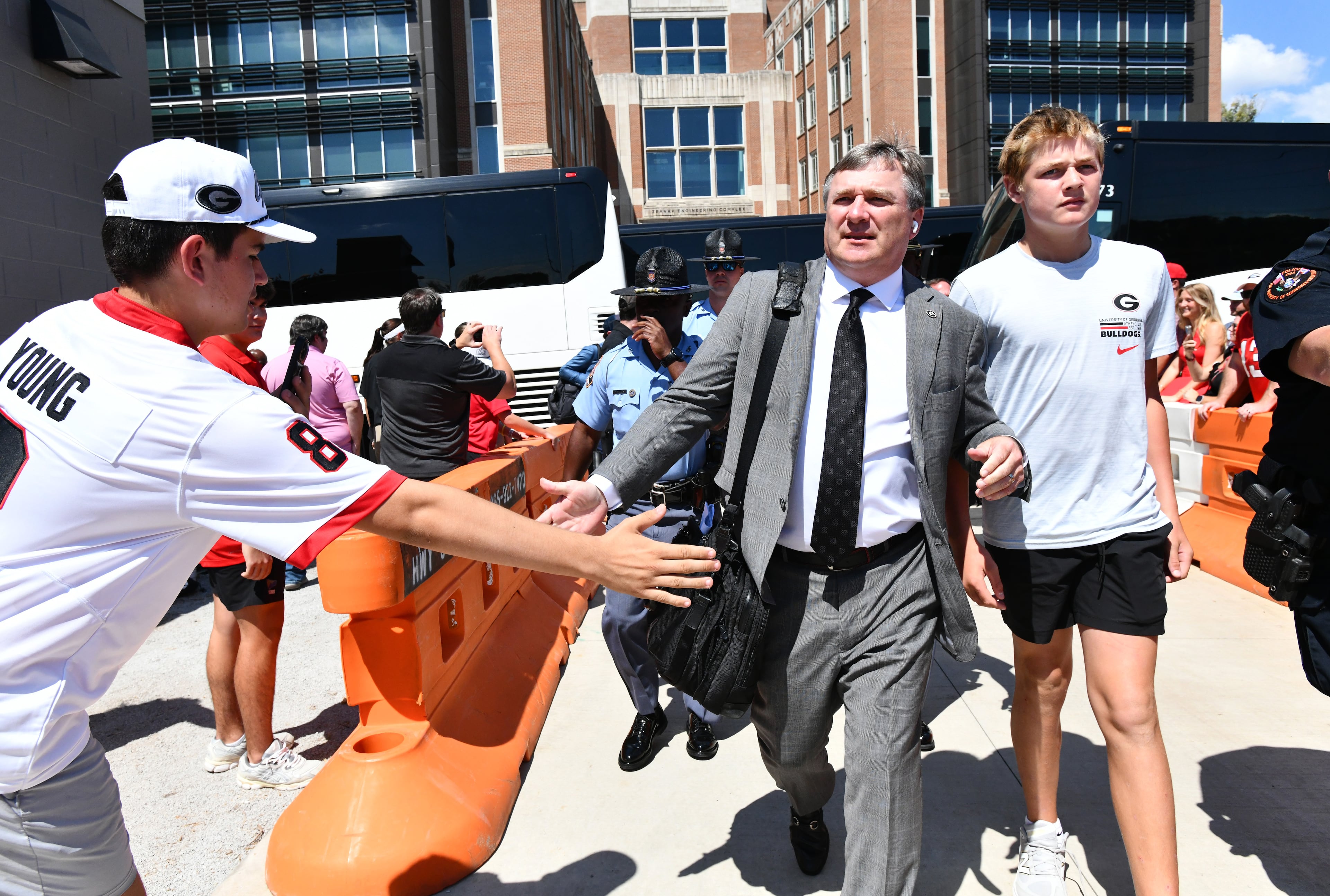 Georgia coach Kirby Smart and son Andrew greet fans as Bulldogs players and coaching staff arrive to play against Tennessee at Neyland Stadium. (Hyusob Shin/AJC)