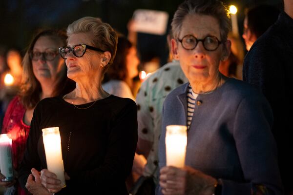 People, including Beverly Evans, left, and Deb Watts, gather for a candlelight vigil in support of the Centers for Disease Control and Prevention in front of its headquarters in Atlanta, Friday, March 28, 2025. (AP Photo/Ben Gray)