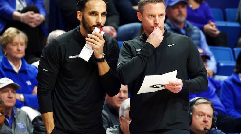 Georgia's assistant coach Erik Pastrana, left, and head coach Mike White study the action during the first half of an NCAA college basketball game against Kentucky in Lexington, Ky., Tuesday, Jan. 17, 2023. (AP Photo/James Crisp)