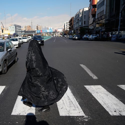 A woman crosses an intersection in downtown Tehran, Iran, Friday, Jan. 16, 2026. (AP Photo/Vahid Salemi)