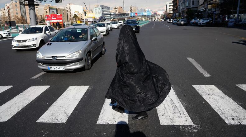 A woman crosses an intersection in downtown Tehran, Iran, Friday, Jan. 16, 2026. (AP Photo/Vahid Salemi)