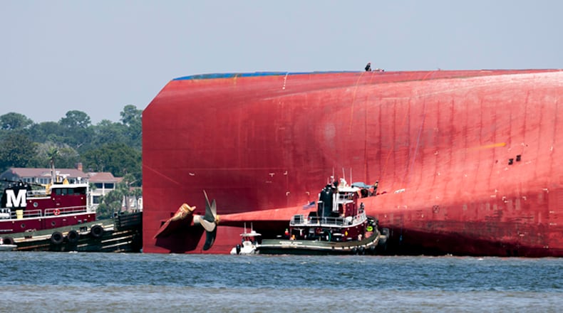 In this Sept. 9, 2019, file photo, rescuers work near the stern of the vessel Golden Ray as it lays on its side near the Moran tug boat Dorothy Moran in Jekyll Island, Ga. Truckloads of rocks are being transported to the Georgia coast to stabilize an overturned cargo ship until it can be removed in pieces.