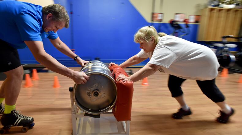 March 25, 2015 Sandy Springs, GA:Randy Nicholson, owner of Fitness Firm Studio in Sandy Springs offers encouragement and resistance via roller skates during Linda Steger's morning workout. After years of not working out, Steger, 66, resumed workouts but found herself getting hurt until she stared going to trainer Randy Nicholson, owner of Fitness Firm Studio. Nicholson specializes in pain therapy and clients over the age of 40. BRANT SANDERLIN/BSANDERLIN@AJC.COM