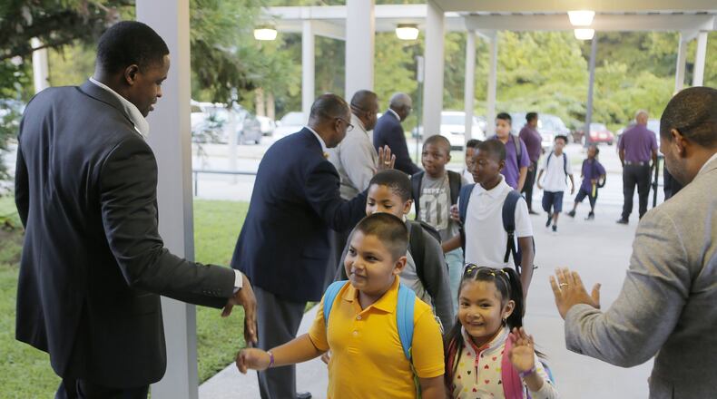 Members of the 100 Black Men of Atlanta greet students as they arrive for the first day of school at Hamilton E. Holmes Elementary in East Point on Aug. 6, 2018. BOB ANDRES /BANDRES@AJC.COM