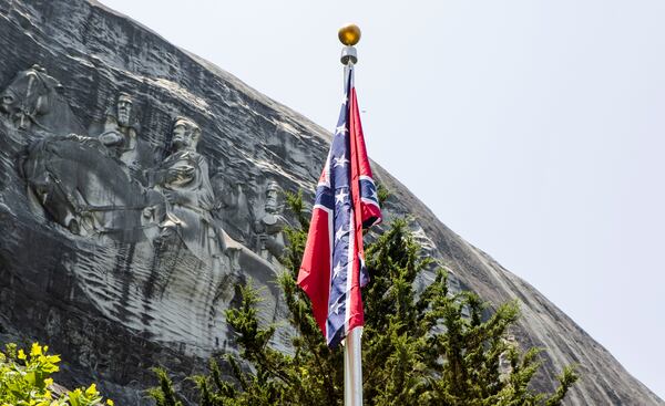 A flag representing the Confederacy flies at the base of Stone Mountain in Valor Park in 2023. (Christina Matacotta for the AJC)