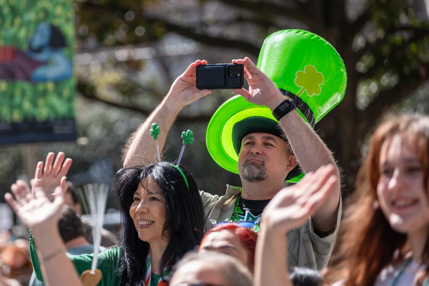 James Donnelly takes a photo as the Atlanta St. Patrick’s Parade moves down Peachtree Street on Saturday, March 14, 2026. (Ben Gray for the AJC)