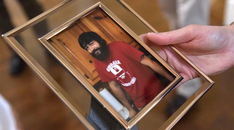 July 25, 2018 Alpharetta - Julie Ivey holds a photograph of her brother Gregg Ivey, who died of a heroin overdose, at Little River Farms on Wednesday, July 25, 2018. Gregg Ivey who loved music and his dog River passed out, stopped breathing and soon died at North Fulton Hospital of an overdose. His friend, Graham Williams, who injected the drug into Ivey’s vein, has been charged with felony murder, with the underlying felony being distribution of heroin. HYOSUB SHIN / HSHIN@AJC.COM
