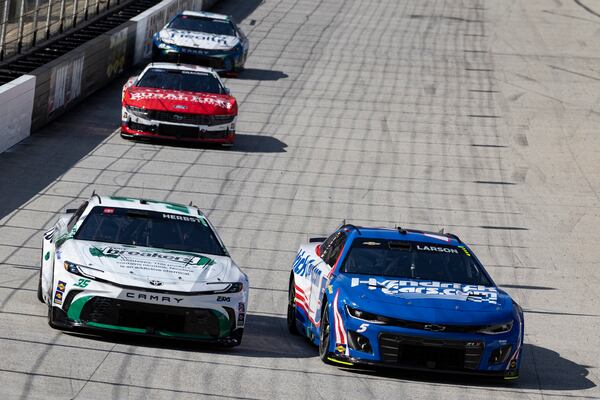 Kyle Larson (5) passes Riley Herbst (35) during a NASCAR Cup Series auto race, Sunday, April 13, 2025, in Bristol, Tenn. (AP Photo/Wade Payne)