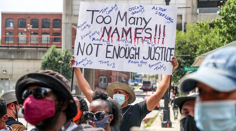 Demonstrators carry signs as they rally outside of the Atlanta City Detention Center, on Sunday, June 14, 2020, to protest against the recent police shooting of Rayshard Brooks, a 27-year-old Black man, who was shot and killed by Atlanta police Friday evening during a struggle in a Wendy's drive-thru line.     Alyssa Pointer / alyssa.pointer@ajc.com
