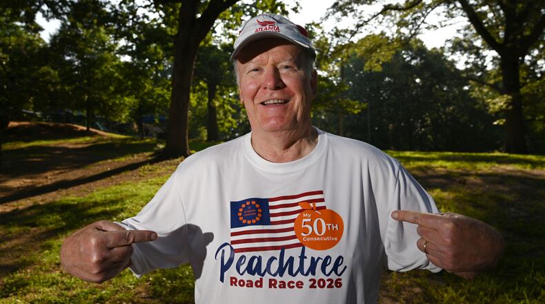 Greg Gates, who will be running his 50th consecutive Peachtree Road Race on July 4, shows off his custom-designed T-shirt, which he'll be wearing on race day. (Hyosub Shin/AJC)