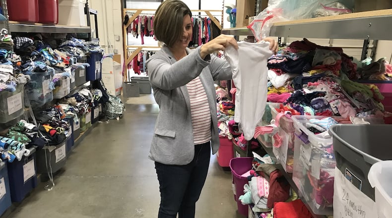 Helping Mamas CEO Jamie Lackey sorts clothing donations at the nonprofit’s Norcross warehouse. CONTRIBUTED