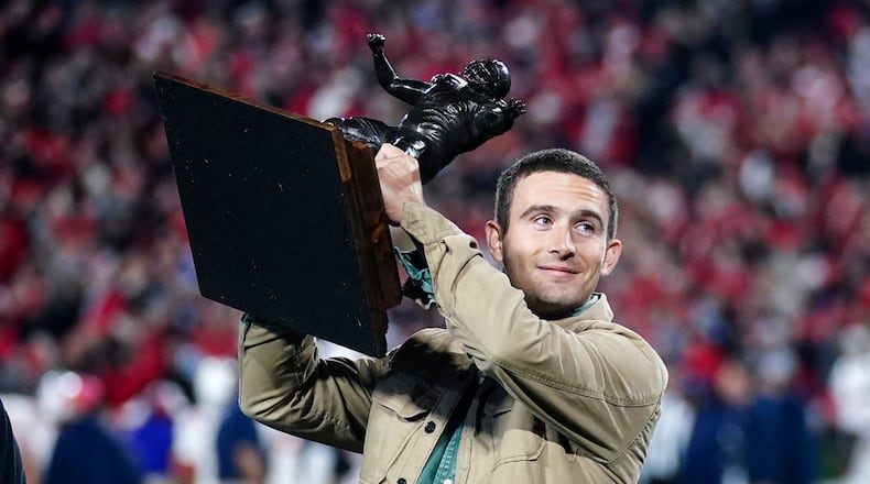 Former Georgia and current Los Angeles Rams quarterback Stetson Bennett holds the Burlsworth Trophy he earned for being college football's top walk-on during the first half of an NCAA college football game between Mississippi and Georgia, Saturday, Nov. 11, 2023, in Athens, Ga. (AP Photo/John Bazemore)