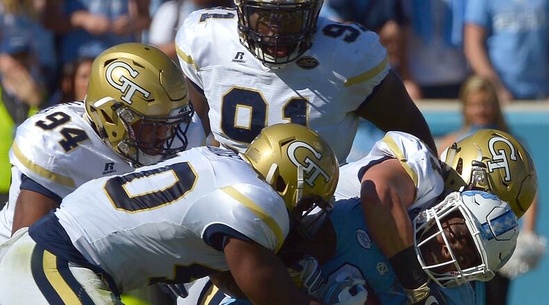Anree Saint-Amour (94), Brandon Adams (90), Patrick Gamble (91) and Rod Rook-Chungong (41) of the Georgia Tech Yellow Jackets tackle T.J. Logan (8) of the North Carolina Tar Heels during the game at Kenan Stadium on November 5, 2016 in Chapel Hill, North Carolina. (Photo by Grant Halverson/Getty Images)