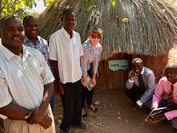 Barbara Mayfield poses in front of a tiny library in the hills above Lake Kariba. Courtesy of Claude and Barbara Mayfield