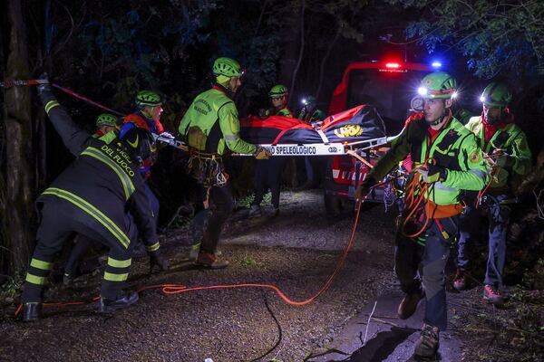 Rescuers recoup the body of one of the victims of a cable car carrying tourists south of Naples which crashed after the cable snapped, killing at least four people and injuring one in Castellamare di Stabia, near Naples, Italy, Thursday, April 17, 2025. (AP Photo/Salvatore Laporta)