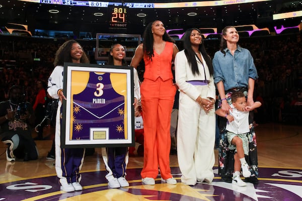 The jersey of former Los Angeles Sparks player Candace Parker, center, looks on with her family during her jersey retirement ceremony during a WNBA basketball game between the Sparks and the Chicago Sky, Sunday, June 29, 2025, in Los Angeles. (AP Photo/Jessie Alcheh)