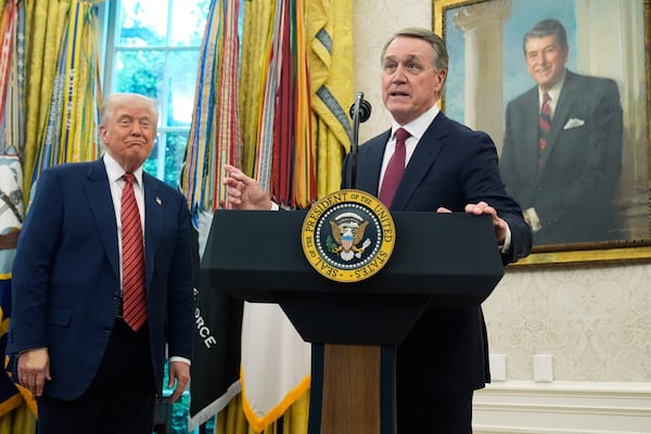 President Donald Trump listens as former Georgia U.S. Sen. David Perdue speaks after being sworn in as the U.S. ambassador to China during a ceremony at the White House on Wednesday.