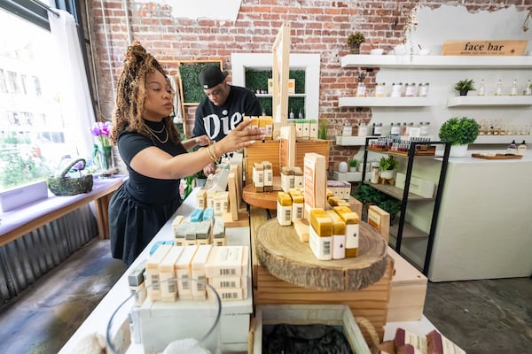 Ty and Aaron Jenkins restock and tidy the soap display at Olive Branch in downtown Decatur. 
(Bita Honarvar for the AJC)