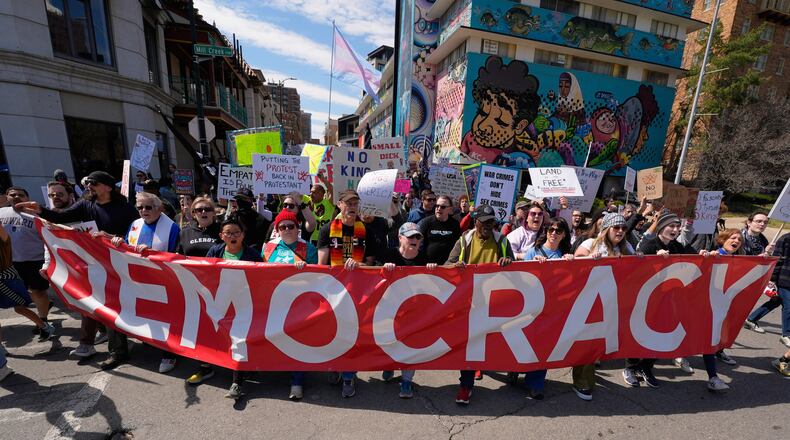 Demonstrators march through the Country Club Plaza shopping district during a "No Kings" protest Saturday, March 28, 2026, in Kansas City, Mo. (AP Photo/Charlie Riedel)
